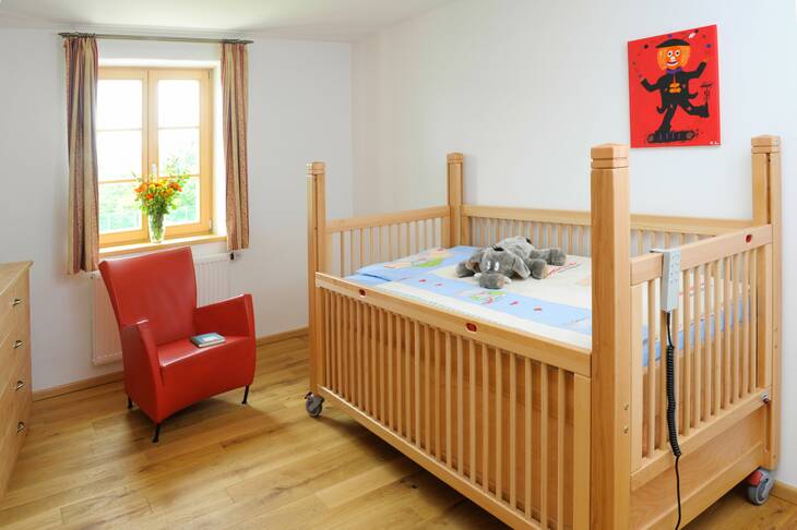 Ein Kinderbett in einem Zimmer der Irmengard-Hofs